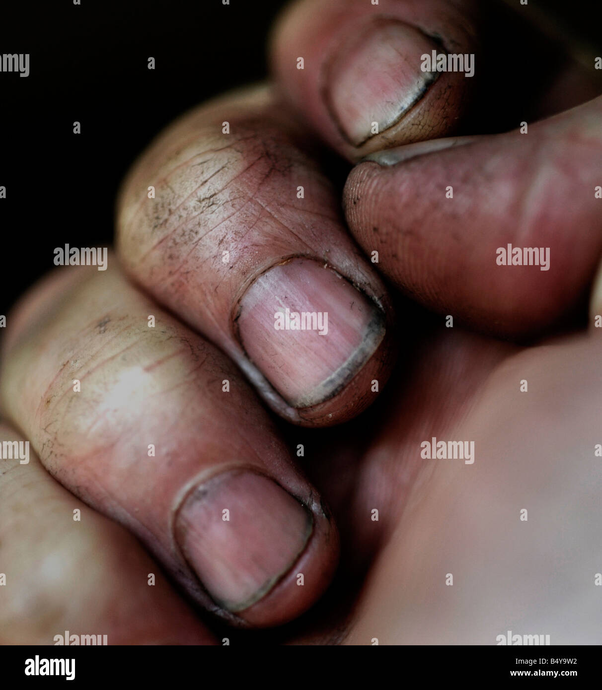 clenched fingers covered in dirt and grime Stock Photo