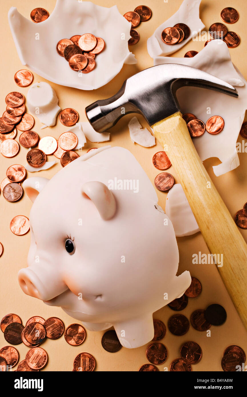 Broken piggy bank with hammer and pennies Stock Photo