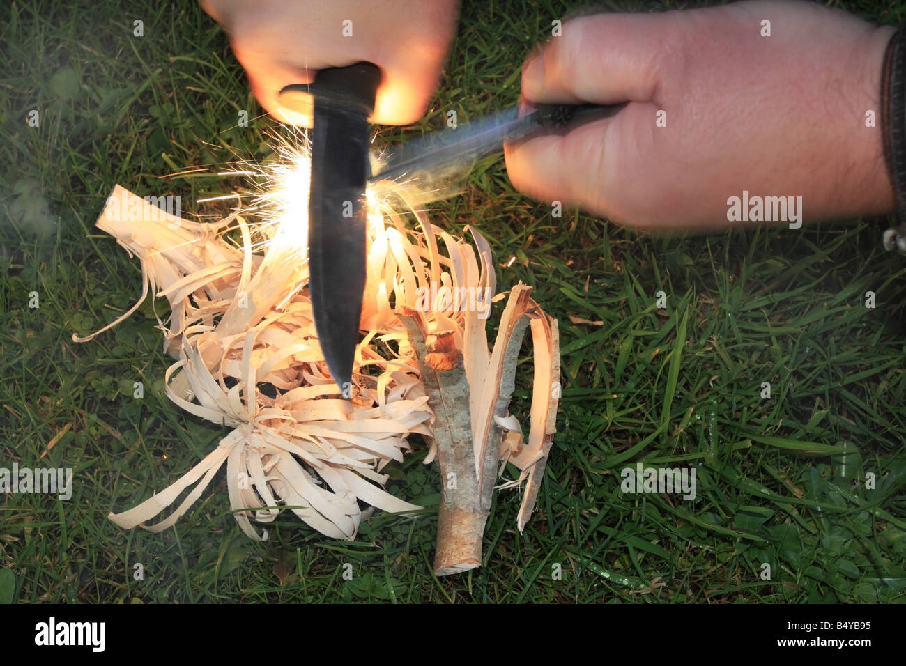 Using a Fire Steel to Ignite Feather Sticks to Create Fire Stock Photo