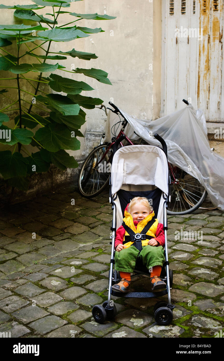 Toddler sitting in his pushchair with the safety harness on Stock Photo -  Alamy