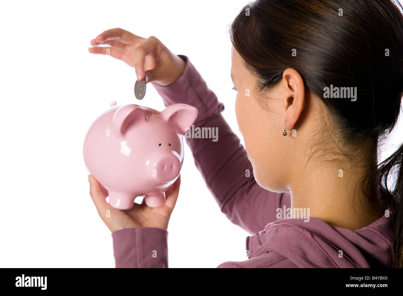 Young asian woman putting money into a piggy bank Stock Photo - Alamy