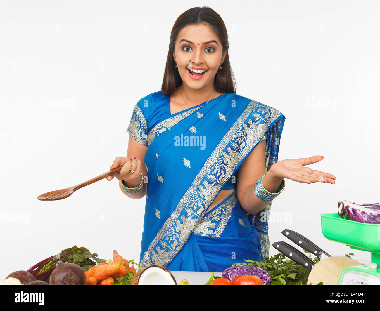 a pretty asian woman of indian origin ready to cook Stock Photo