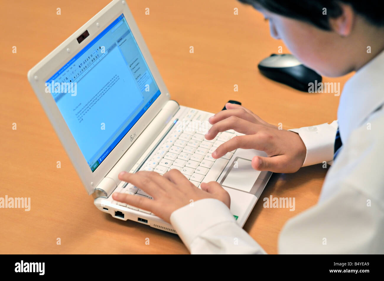 Ten year old schoolboy using an ASUS Eee PC sub notebook computer running Windows XP Stock Photo