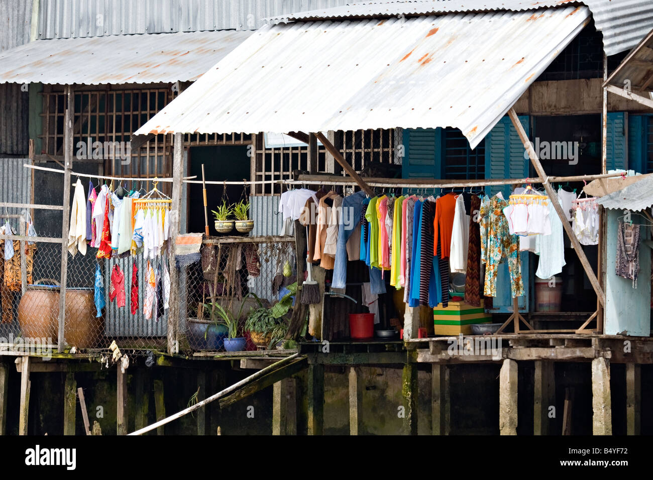 Hanging and drying washed clothings at house on wooden stilts Stock Photo