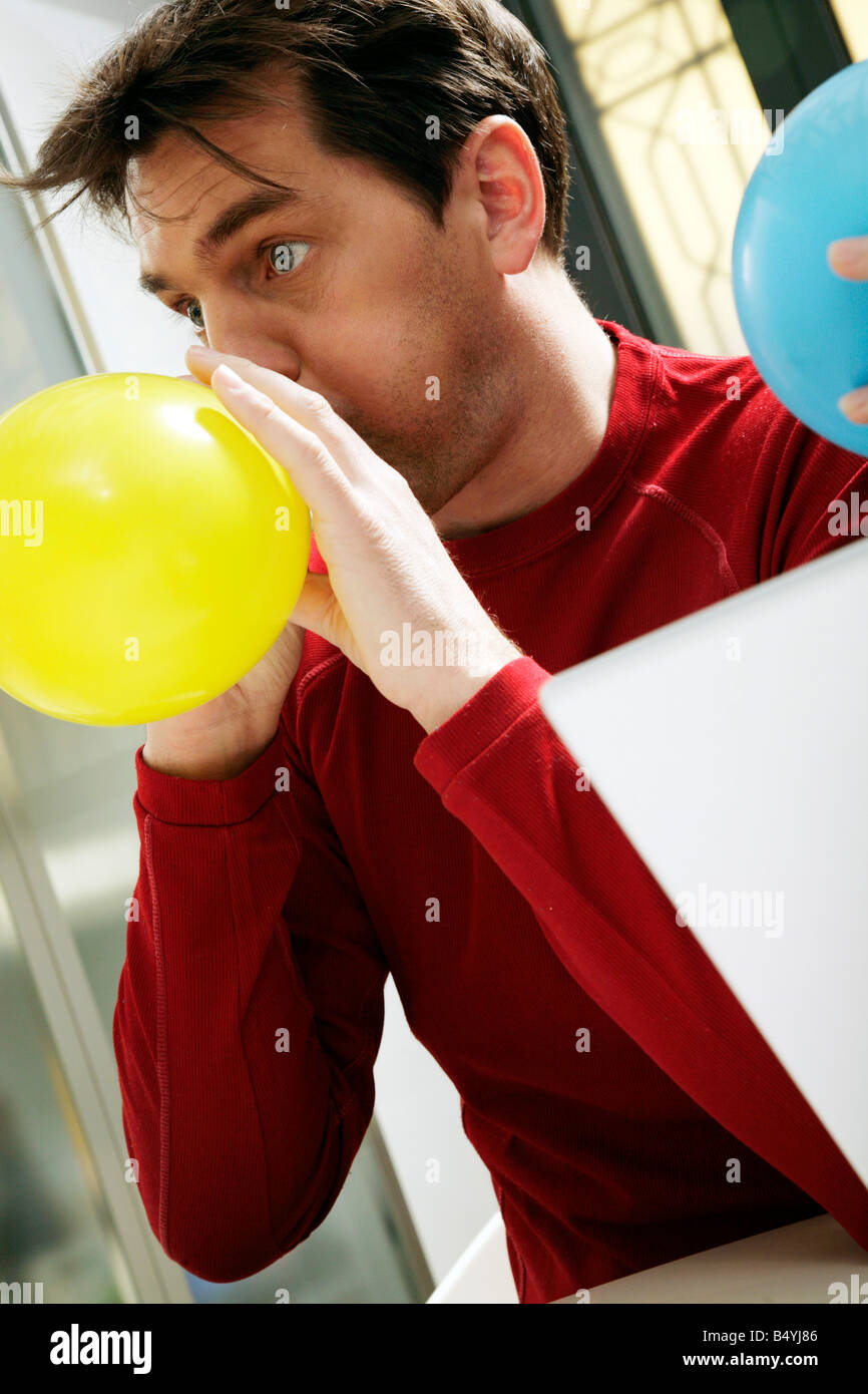 man inflating a balloon Stock Photo