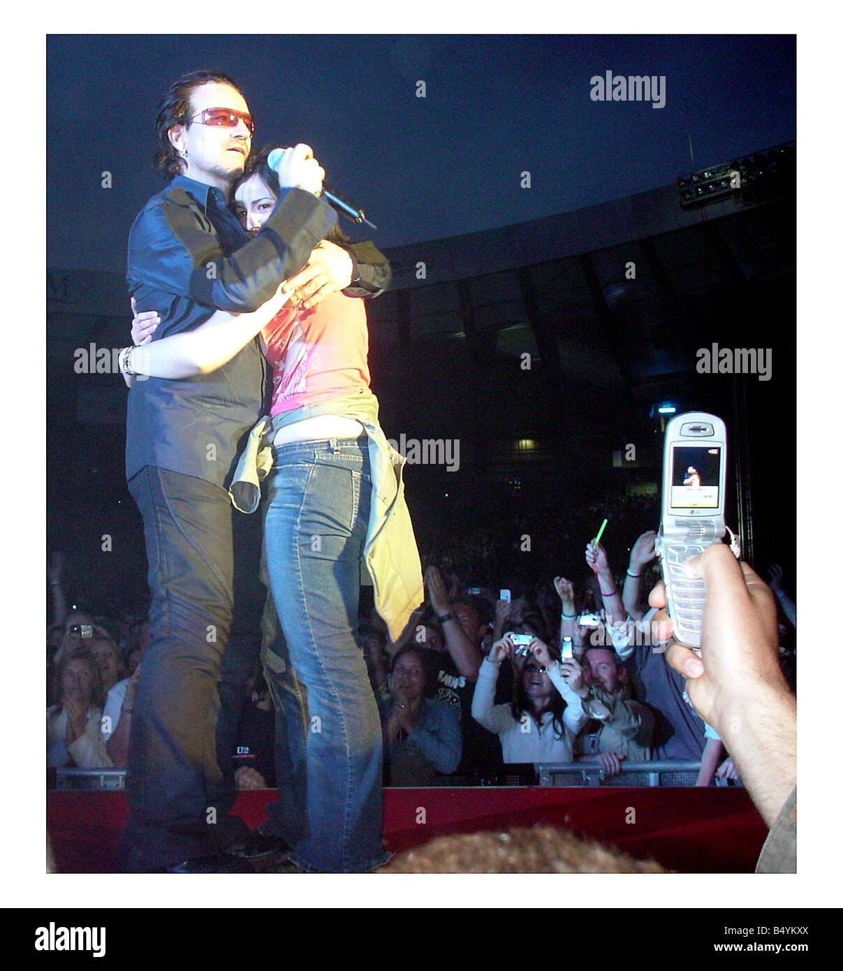 U2 on stage at Hampden Glasgow June 2005 Maria pia Coppola of Hillview terrace Corstorphine who was plucked from the crowd by Bono at last nights gig in Hampden cuddling hugging crying Stock Photo