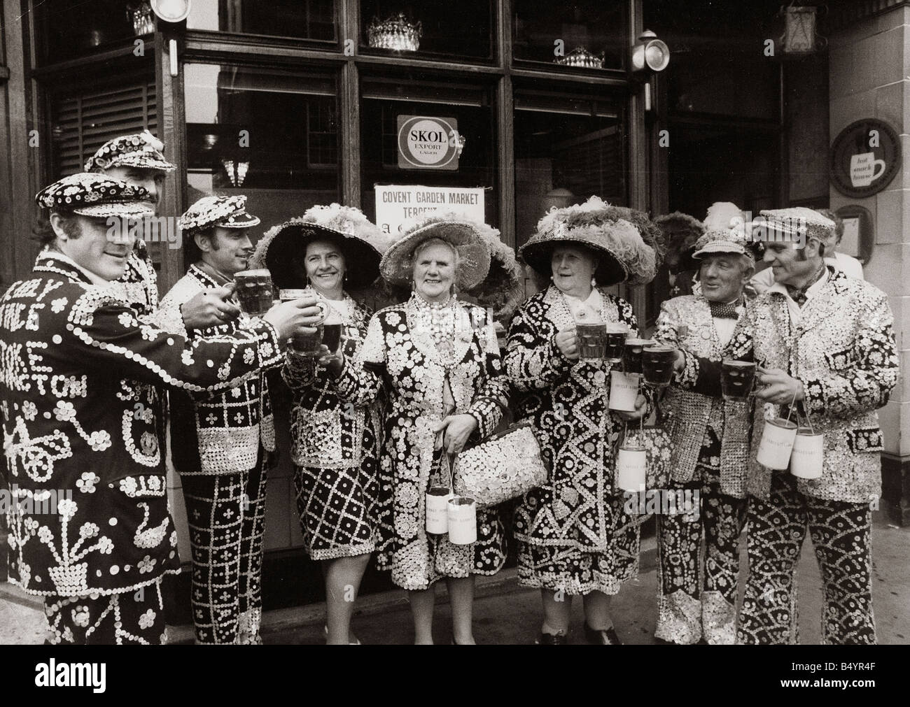 Pearly Kings and Queens celebrate Covent Gardens 300th Birthday Costers Hats Buttons Holding Beer Glasses Collecting Tin Charity Toast Drinking Pub Custom London Men Women Cheers May 1970 1970s Mirrorpix everettselected Stock Photo
