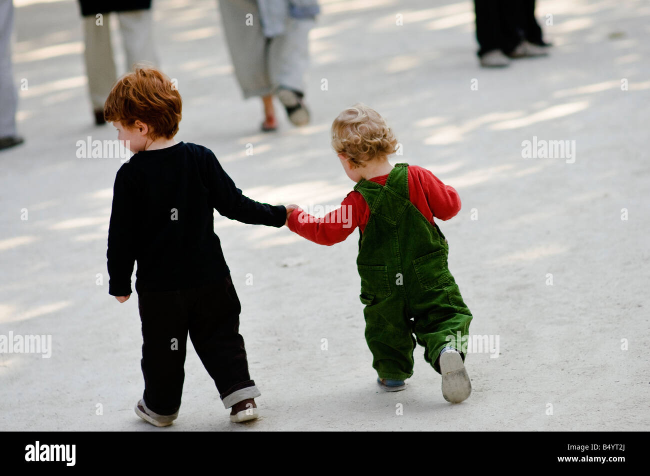Two young brothers walking in a park holding hands Stock Photo - Alamy