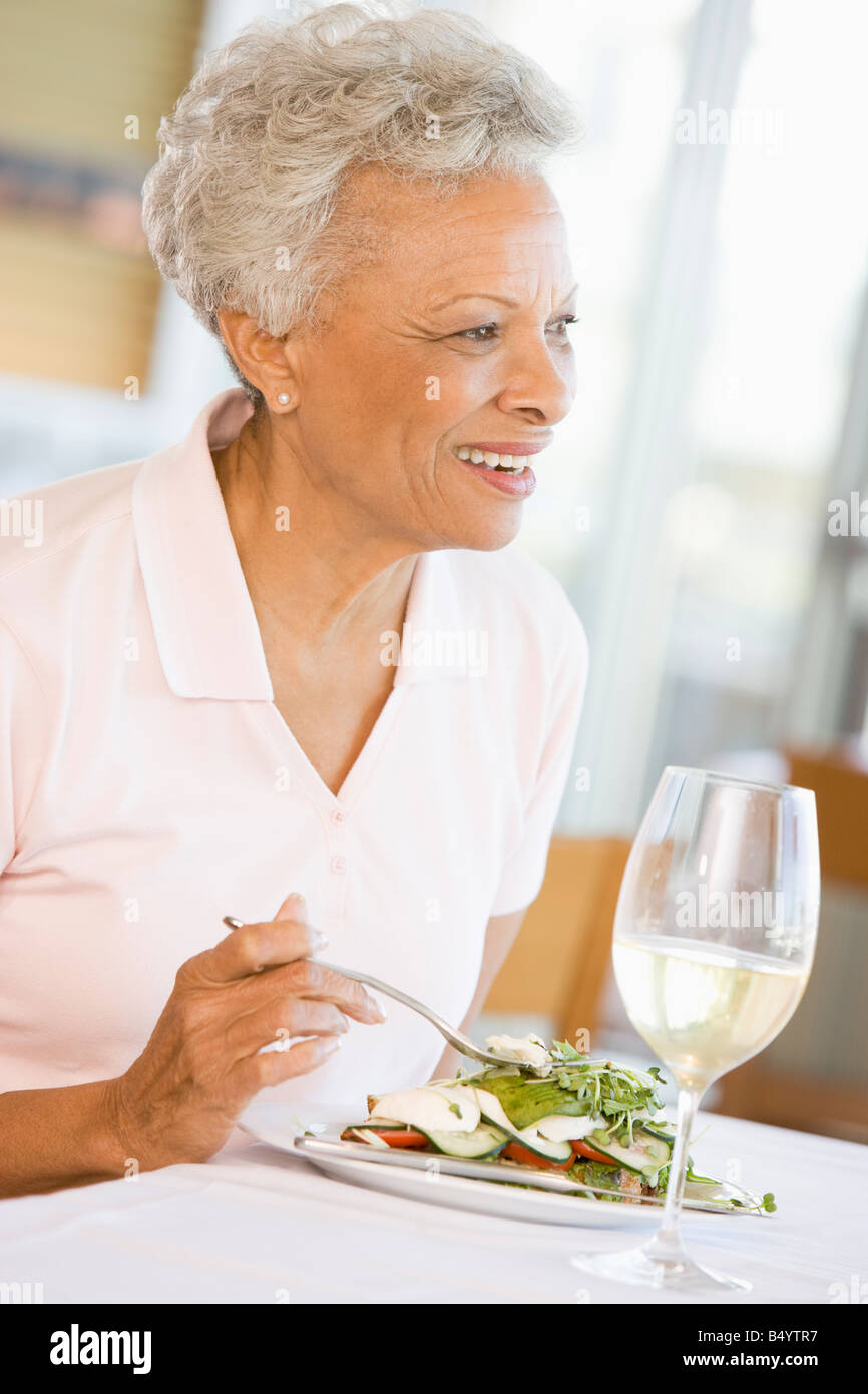 Woman Enjoying Meal With A Glass Of Wine Stock Photo