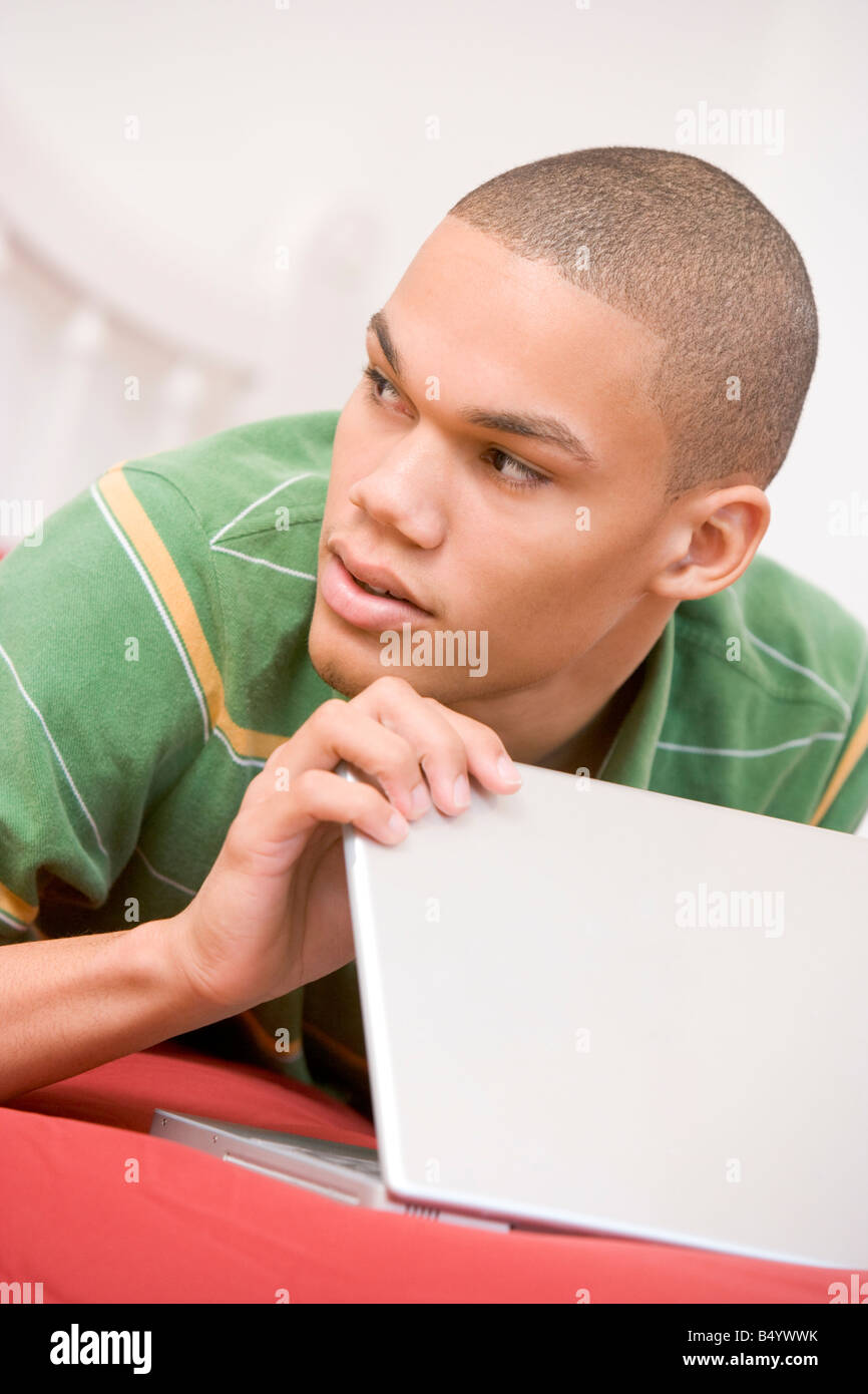 Teenage Boy Lying On Bed Using Laptop Stock Photo - Alamy