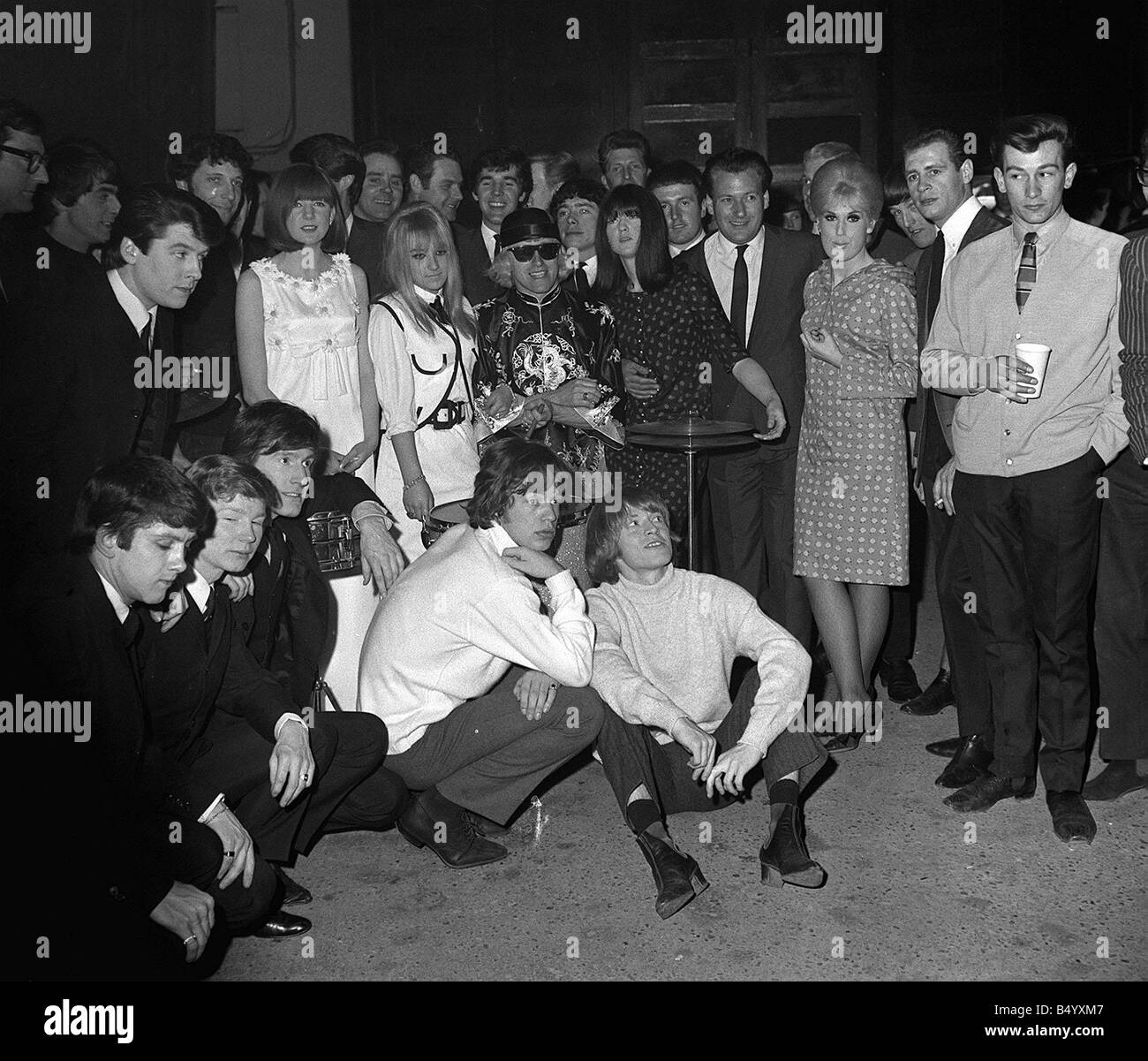 One or two famous names from the world of pop music photographed together after a concert in 1965 They include Mick Jagger and Brian Jones of the Rolling Stones who had just started down the road to international superstardom A young Dusty Springfield with the DJ Jimmy Saville Tom Jones the legendary Welsh crooner and at his side Priscilla White or Cilla Black as we know her now Keith Fordyce Not forgetting of course Twinkle and Cathy McGowan To the left of the pictured the four gentleman dress in dark suits are The Searchers Stock Photo