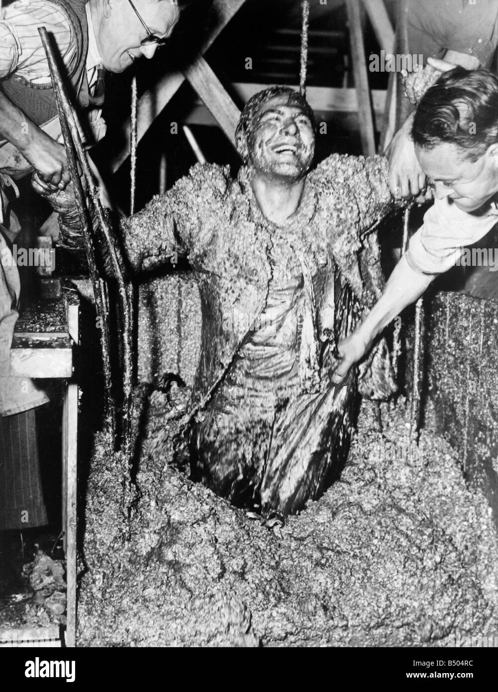 Another fine mess I've gotten myself into. Sam Wanamaker buried in liquid concrete for the filming of Give Us This Day. 1949 Stock Photo