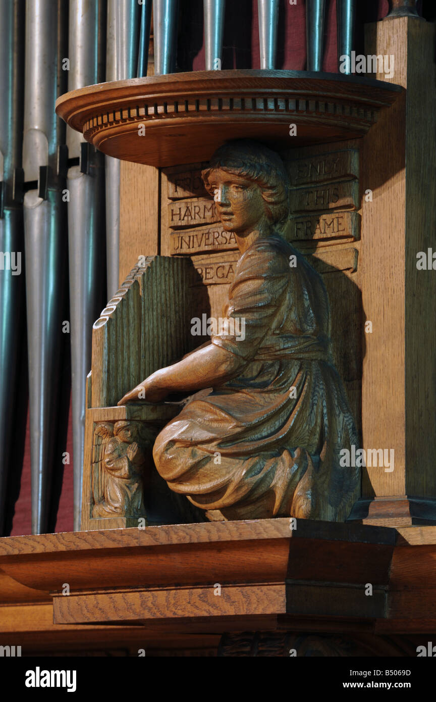 Girl playing organ. Wooden carving on organ case. Church of Saint Mary and Saint Michael, Great Urswick, Cumbria, England. Stock Photo