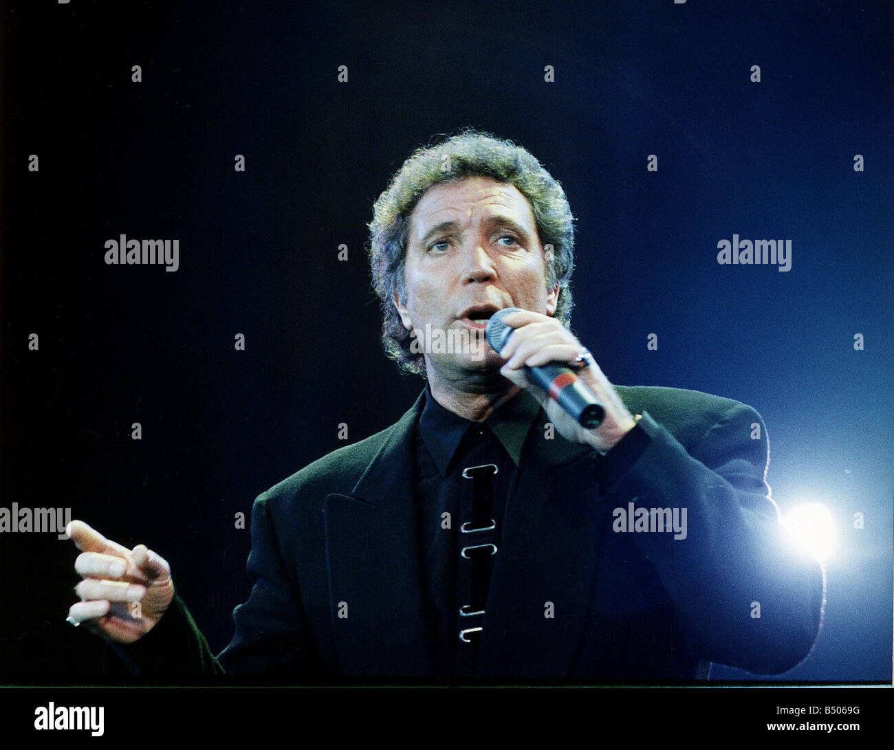 Tom Jones singing at Wembley Holding Microphone Stock Photo Alamy