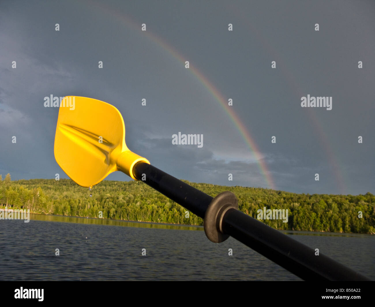 Rainbow with yellow kayak paddle with water droplets in New Brunswick, Canada Stock Photo