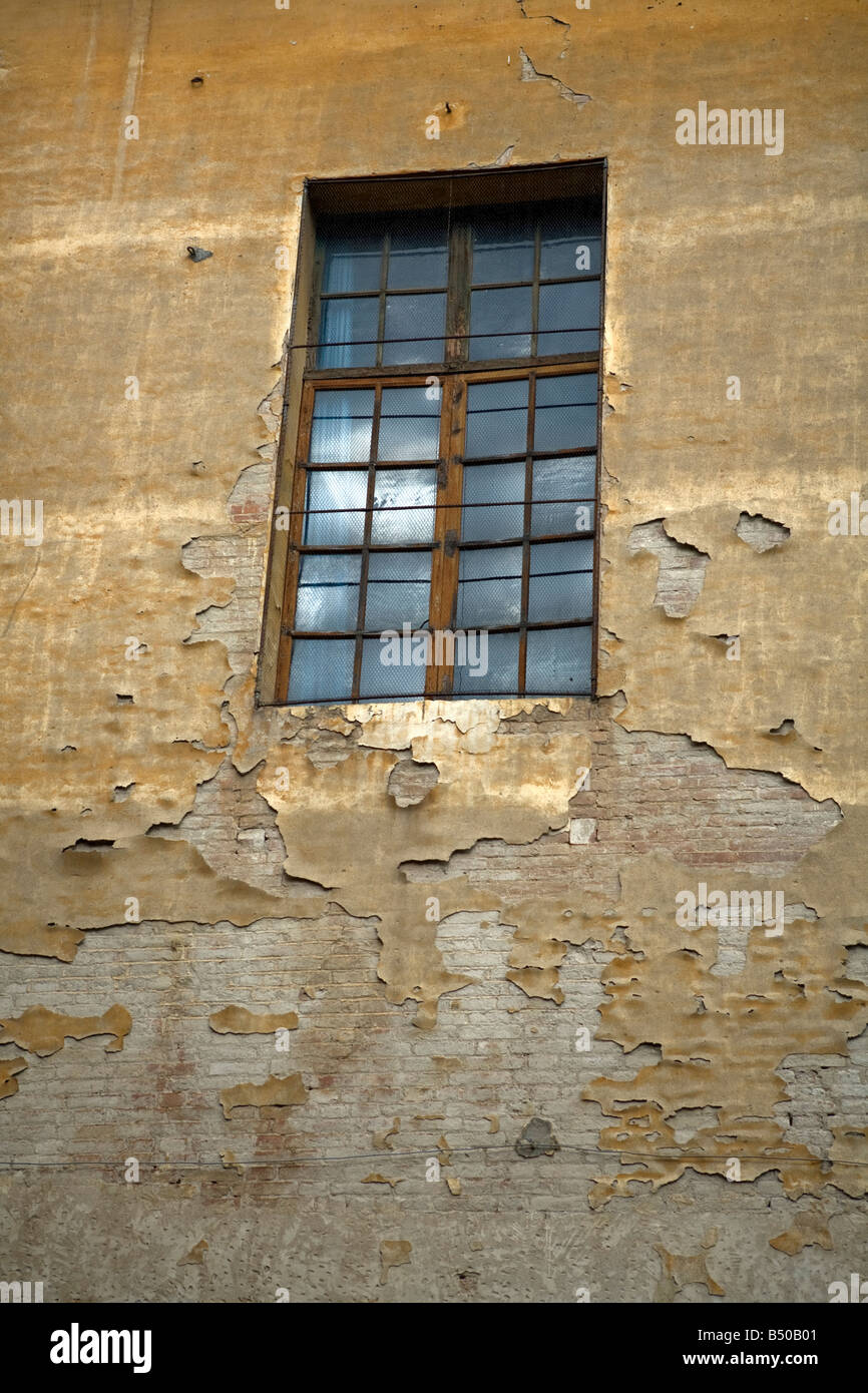 Cracked paint on a wall and windows detail - via pier andrea mattioli - Sienna - Tuscany - Italy Stock Photo