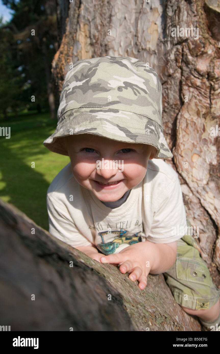 Child sitting on tree branch Stock Photo