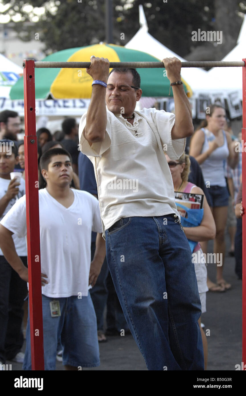 Visitors to a US Marine Corps recruiting booth at a street fair demonstrate their pull up abilities Stock Photo