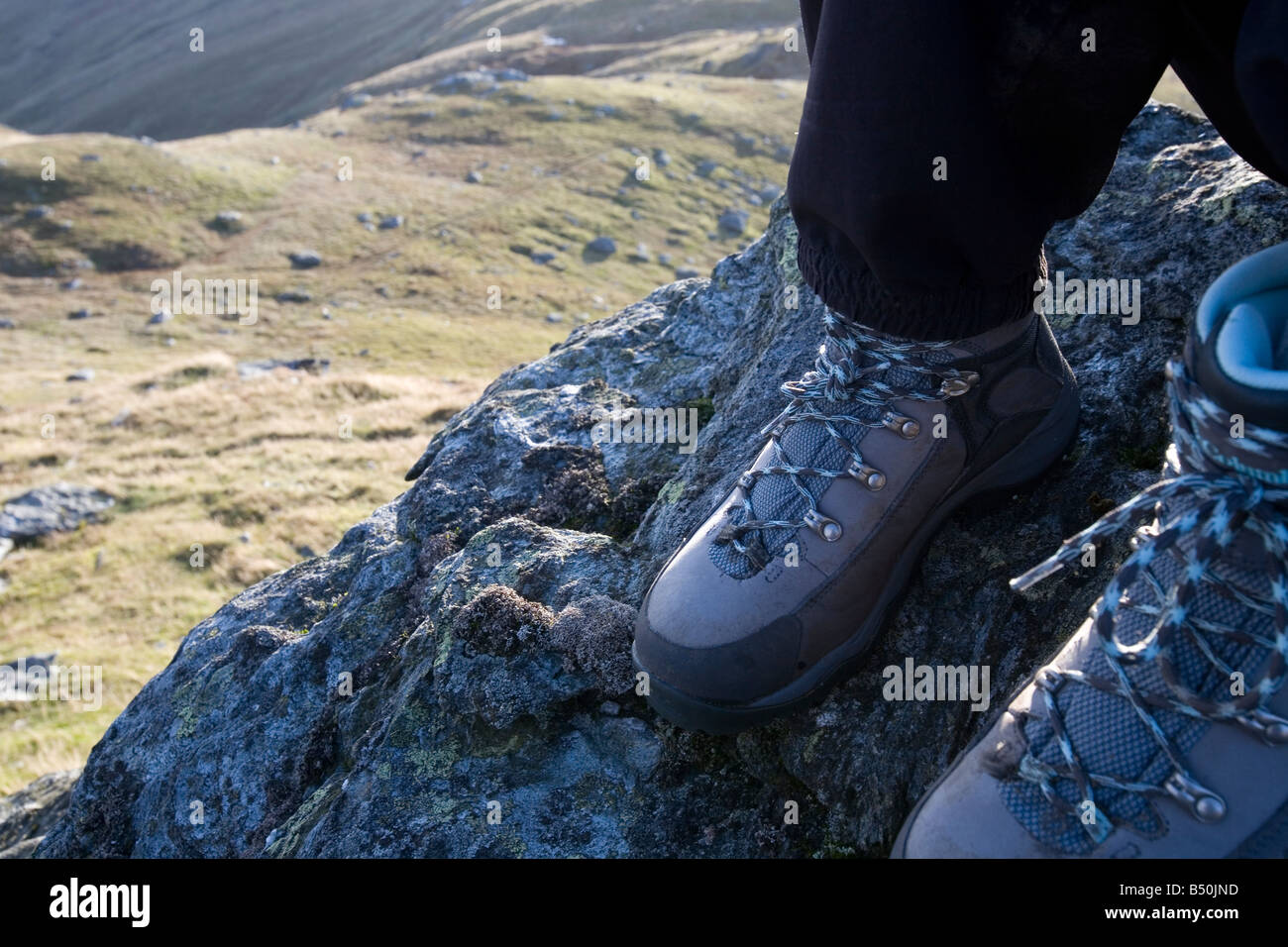 walking boots on a rock with mountain landscape background Stock Photo
