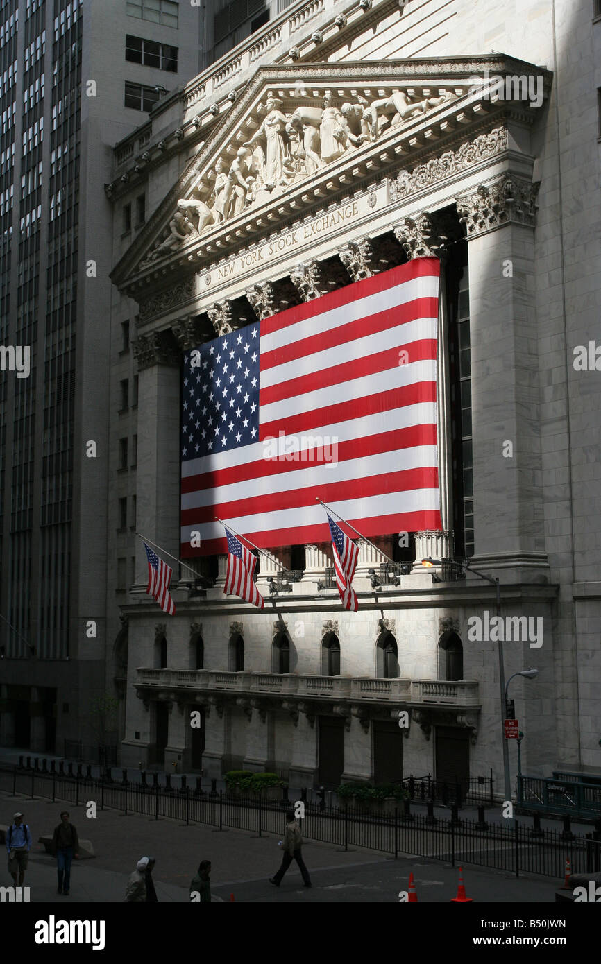 The New York Stock Exchange with a gigantic American flag draped in front on Wall Street Stock Photo