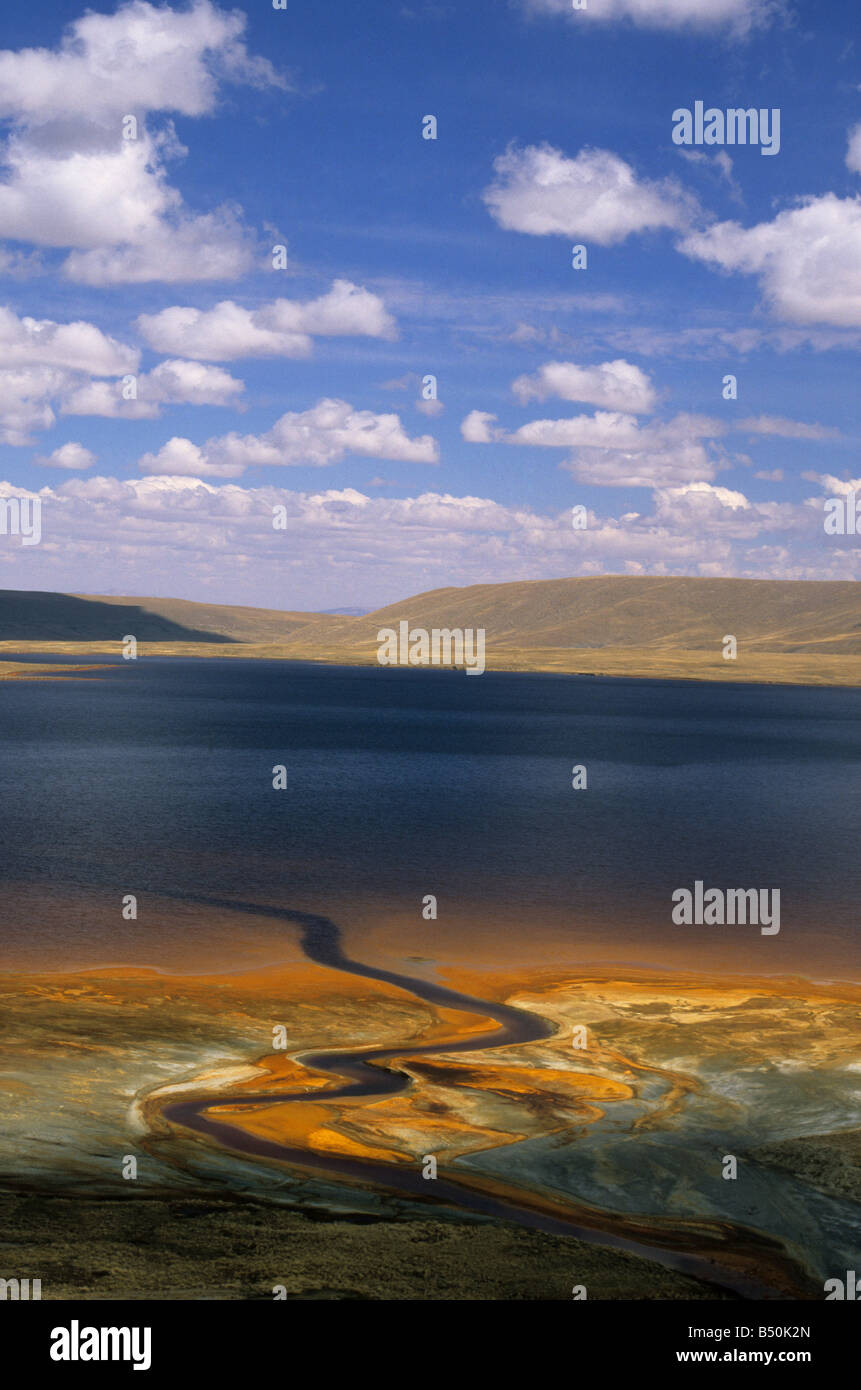 Stream contaminated by acid mine drainage and industrial waste from nearby Milluni tin mine entering Lake Milluni, near La Paz, Bolivia Stock Photo