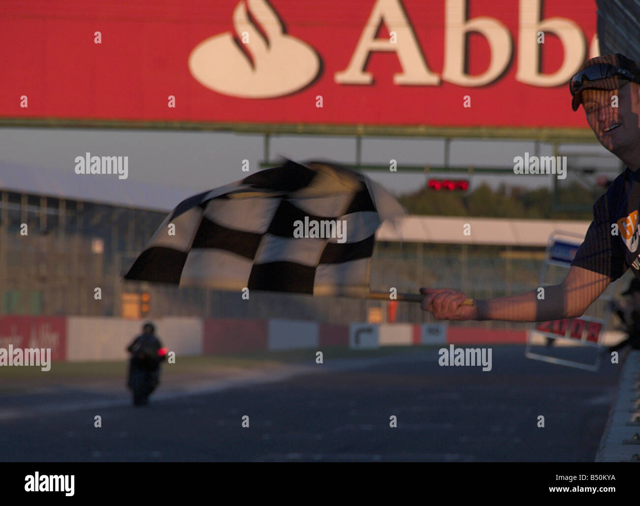 Chequered Flag being Waved at the End of a Motorcycle Endurance Race Stock Photo