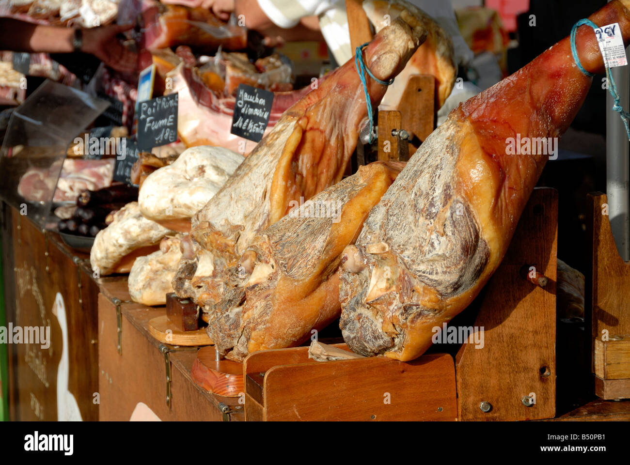 Stock photo of cured hams for sale on a French market stall The image