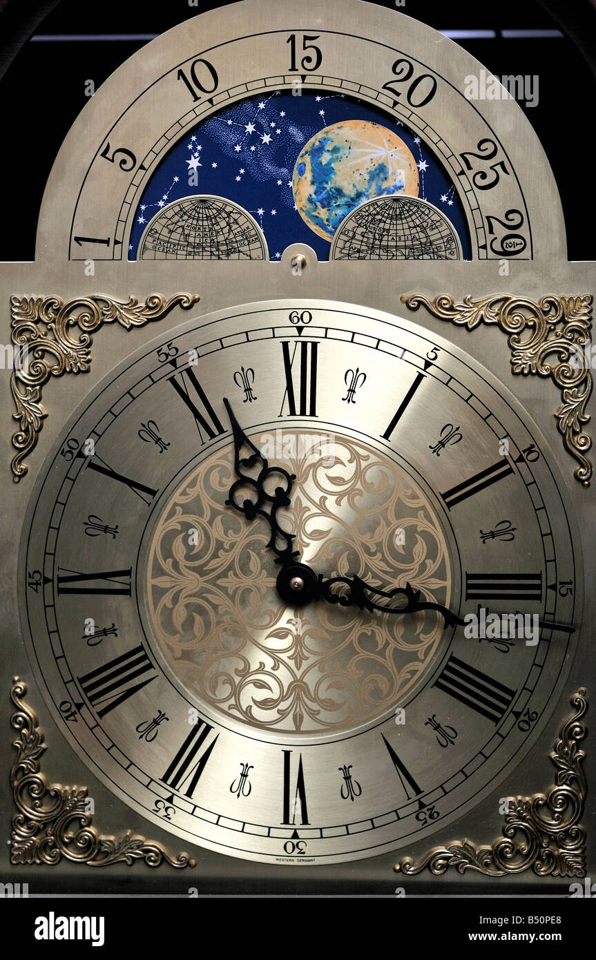 Close up of the clock face of a grandfather clock including a moon dial showing the phases of the moon Stock Photo