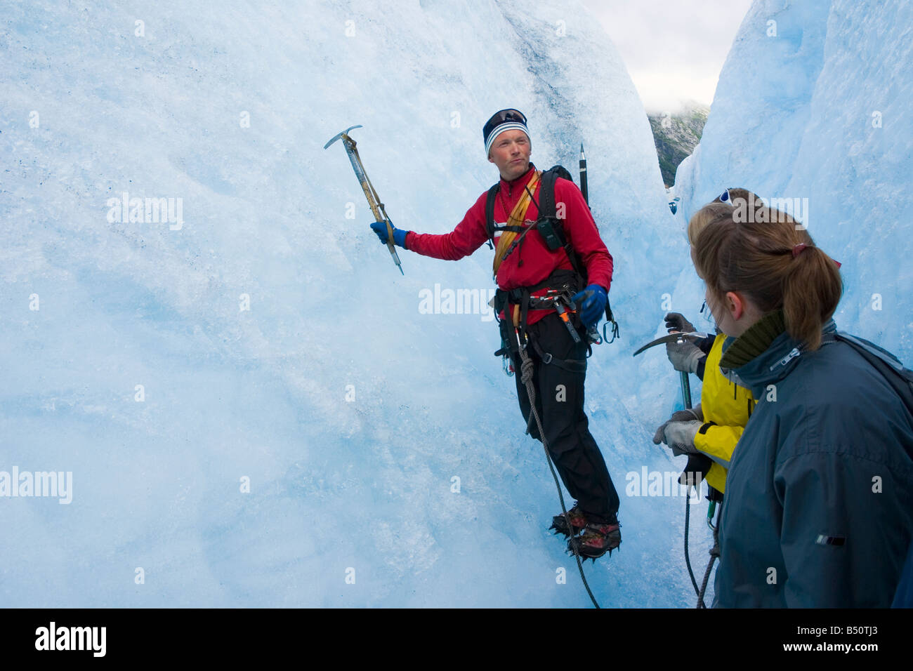 Instructor shows climbing technique to the beginners ice climbers Stock