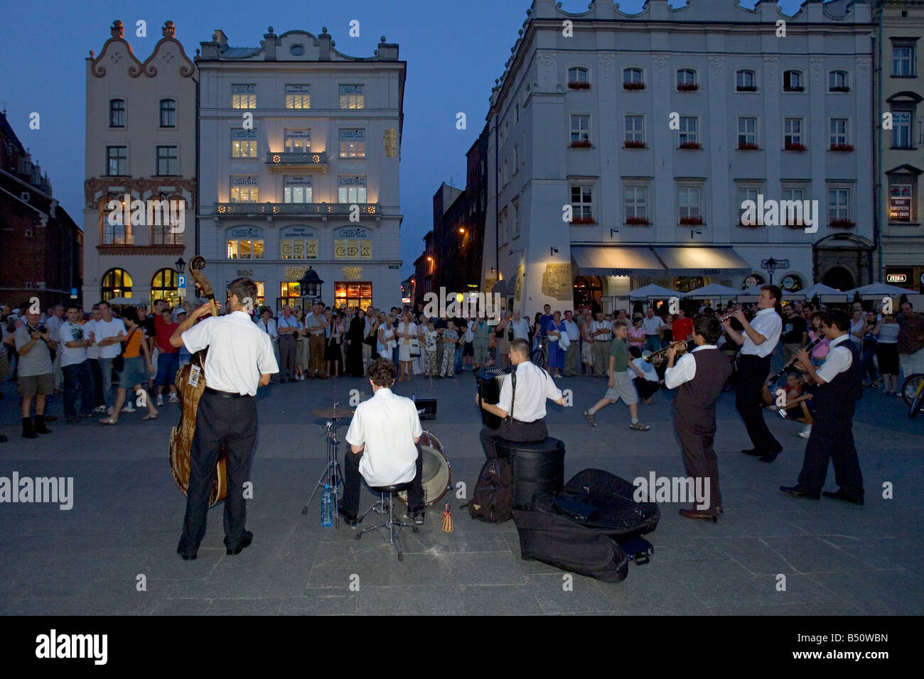 Street performers playing in the Main Market Square of Krakow at dusk. Stock Photo