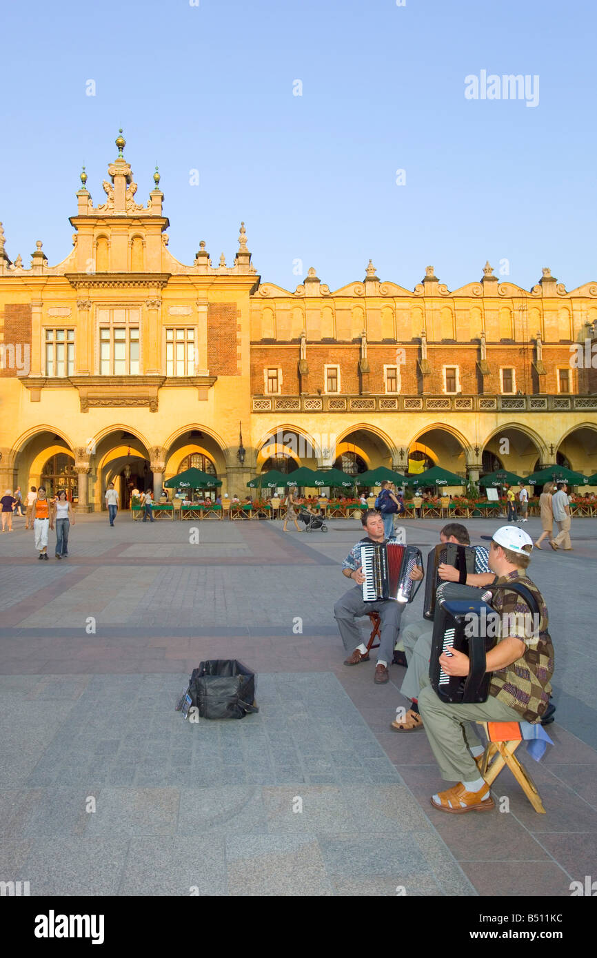 Street performers playing in the Main Market Square of Krakow with the Sukiennice Cloth Hall building in the background. Stock Photo