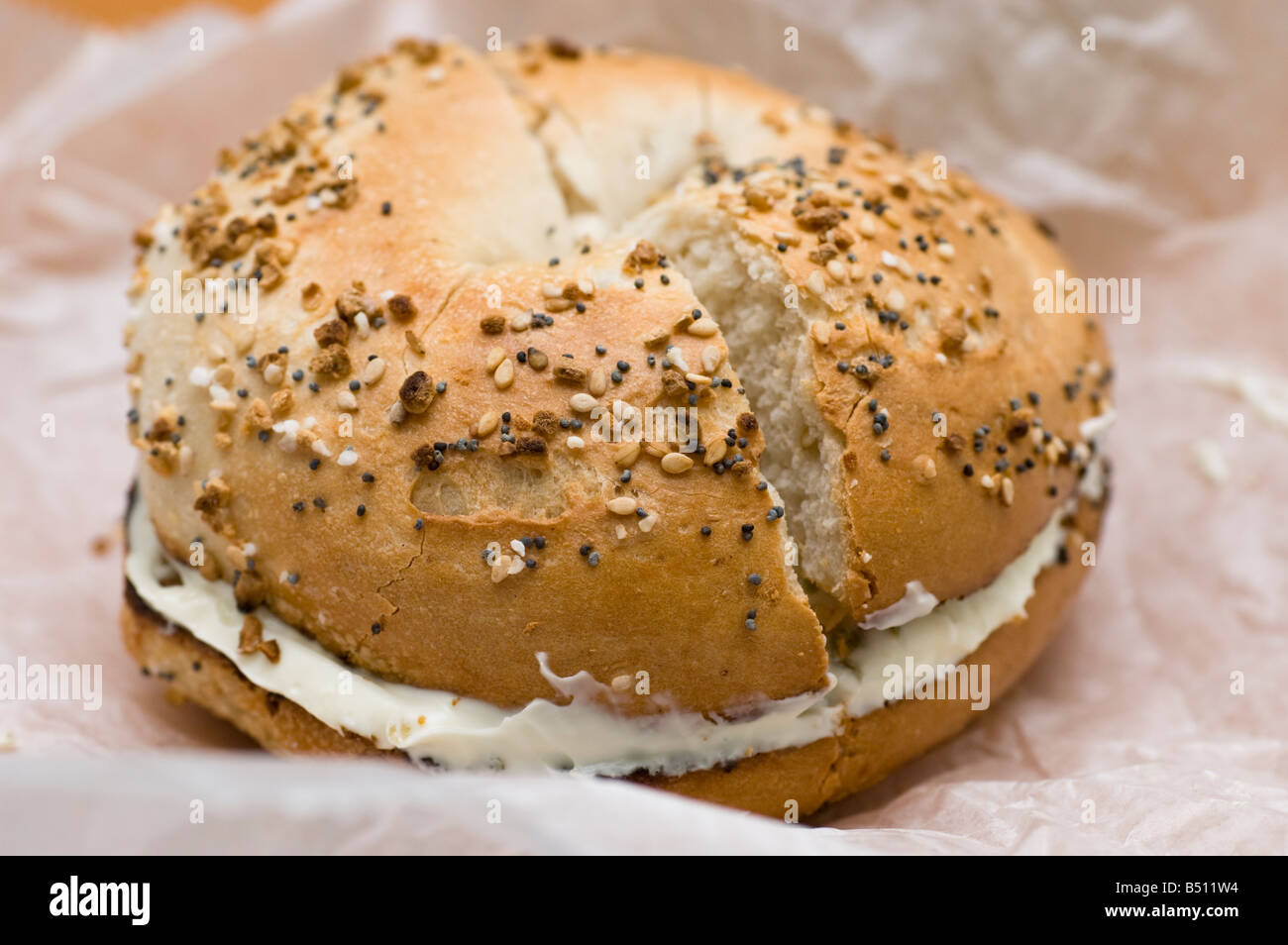 Everything Bagel with Cream Cheese, Sliced, on Wax Paper Stock Photo