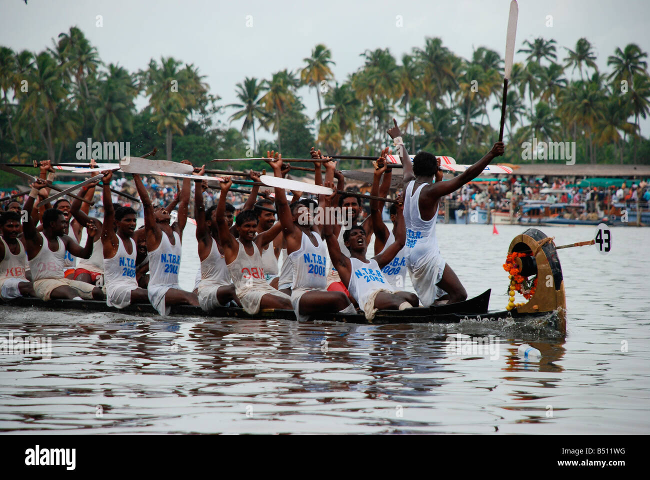 Winners raising hands to show their victory in a boat race in Kerala