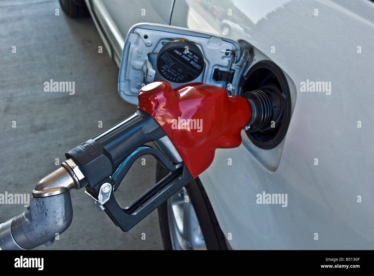 Gas pump nozzle anti-spill device for use with conventional fuel delivery pumps to eliminate spillage and loss of fuel Stock Photo
