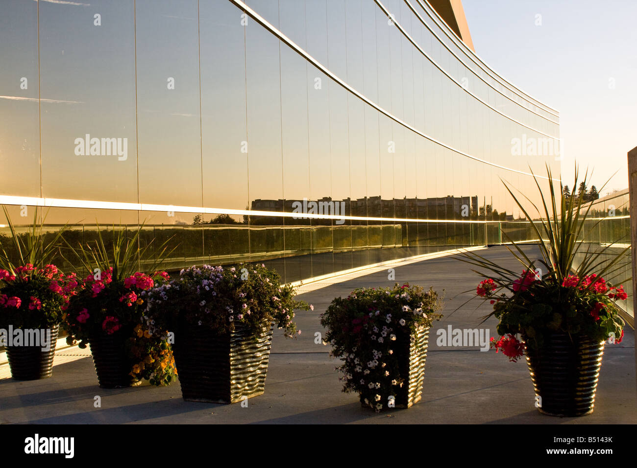 Flower planters and the sky reflected in an allglass building in
