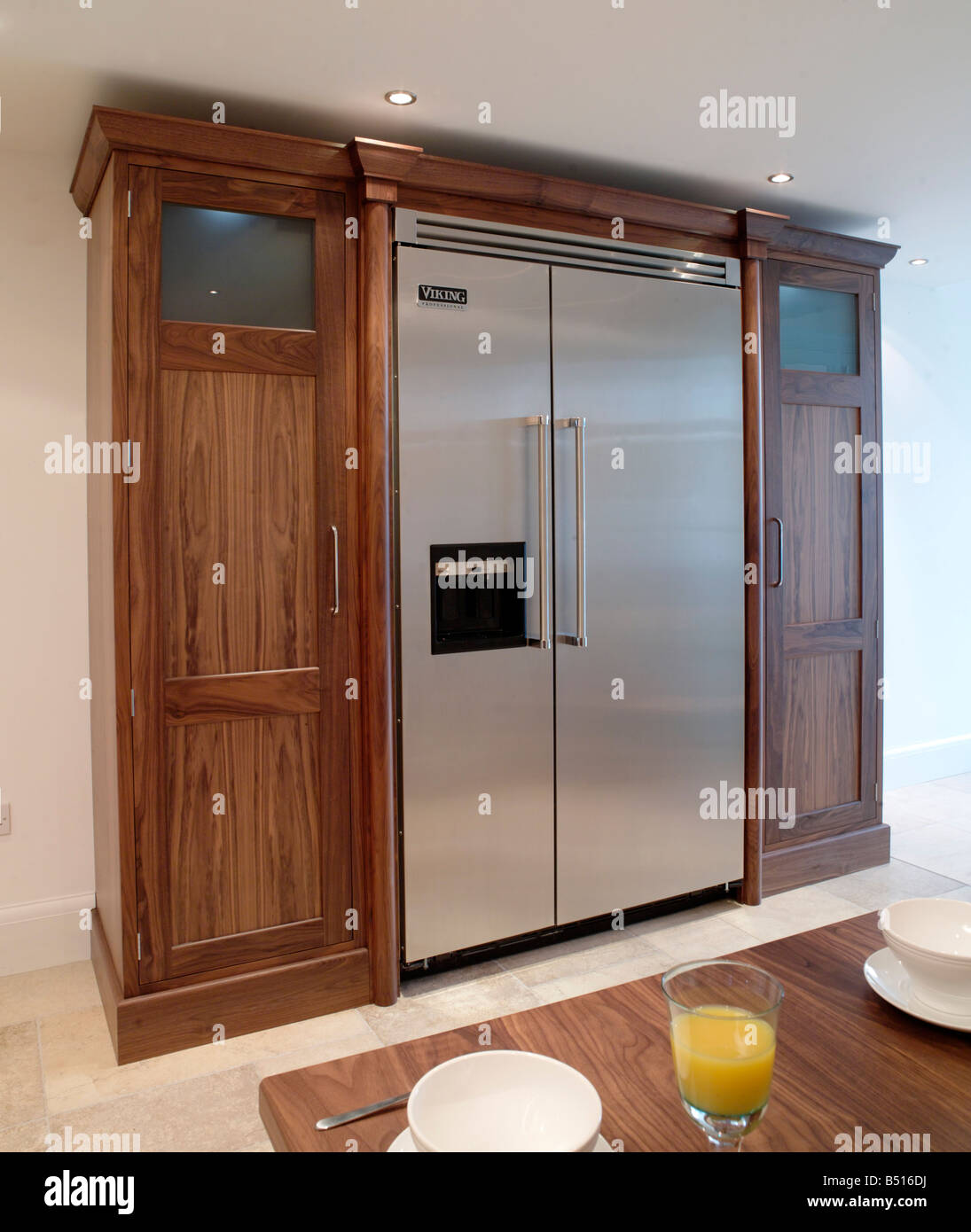 Free standing fridge freezer enclosure with storage and finished in dark wood Stock Photo