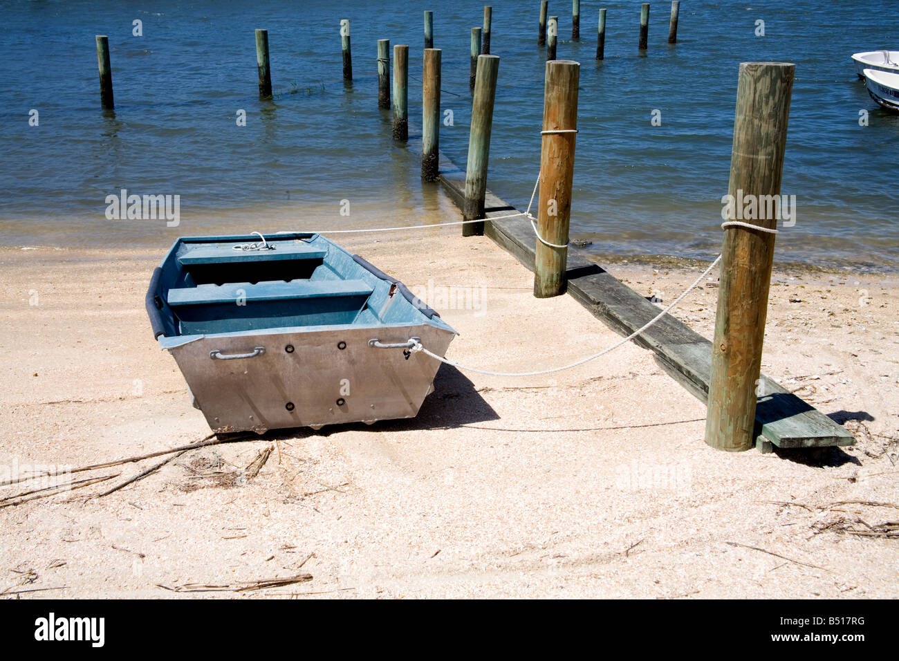 Boat by wooden pilings near a calm bay in St. Augustine, Florida Stock Photo