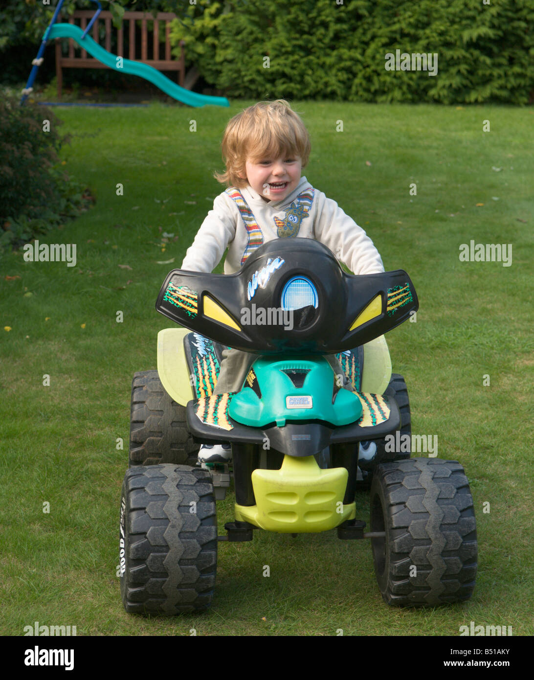 young child, boy, driving a child's quad bike machine in garden, three year old boy, UK Stock Photo