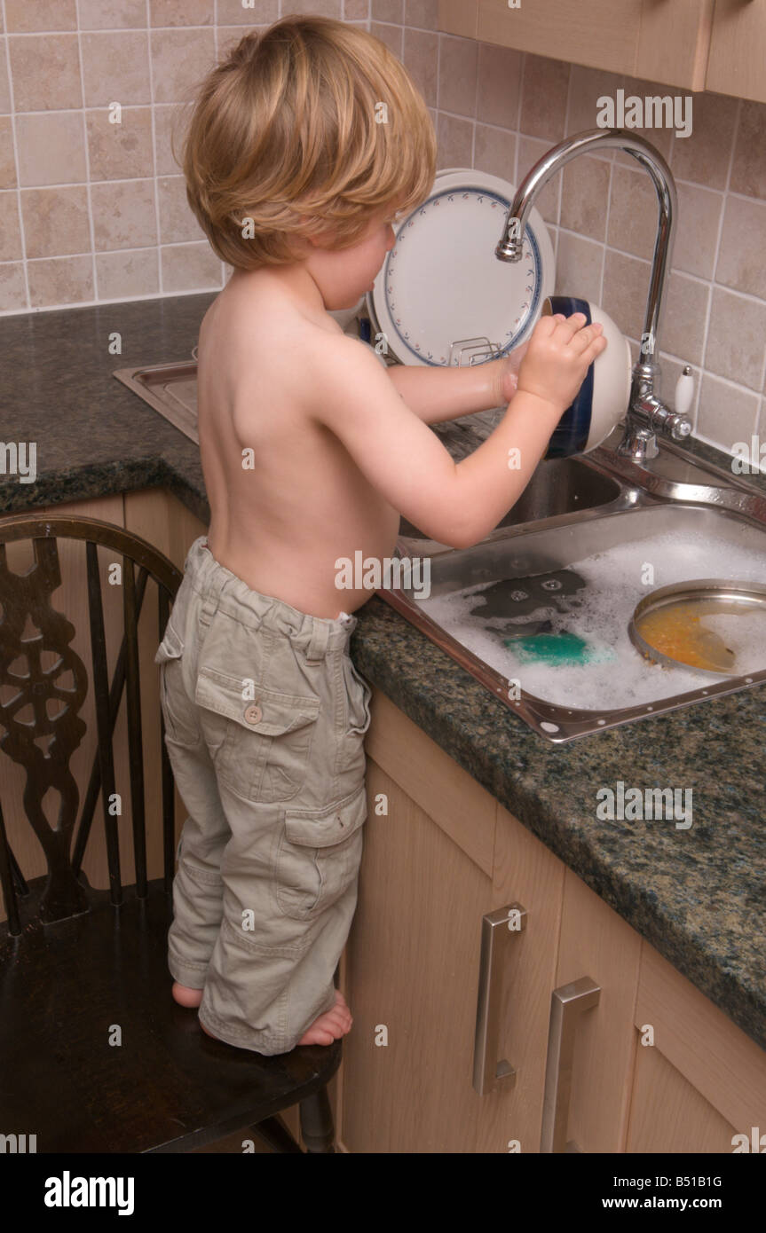 https://c8.alamy.com/comp/B51B1G/toddler-boy-child-washing-up-kitchen-sink-doing-the-dishes-with-hot-B51B1G.jpg