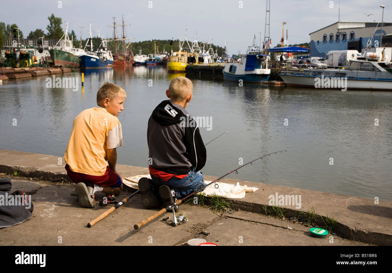 Boys fishing in harbour Leba Poland Stock Photo