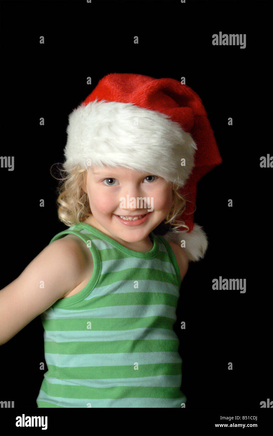 White girl wearing a red christmas hat and green stripy vest. Stock Photo