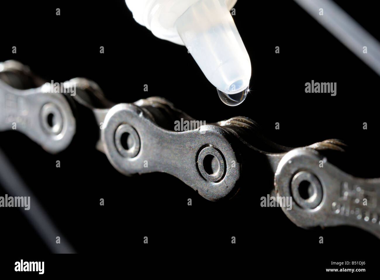 Close up of lubricant being applied to a bicycle chain Stock Photo