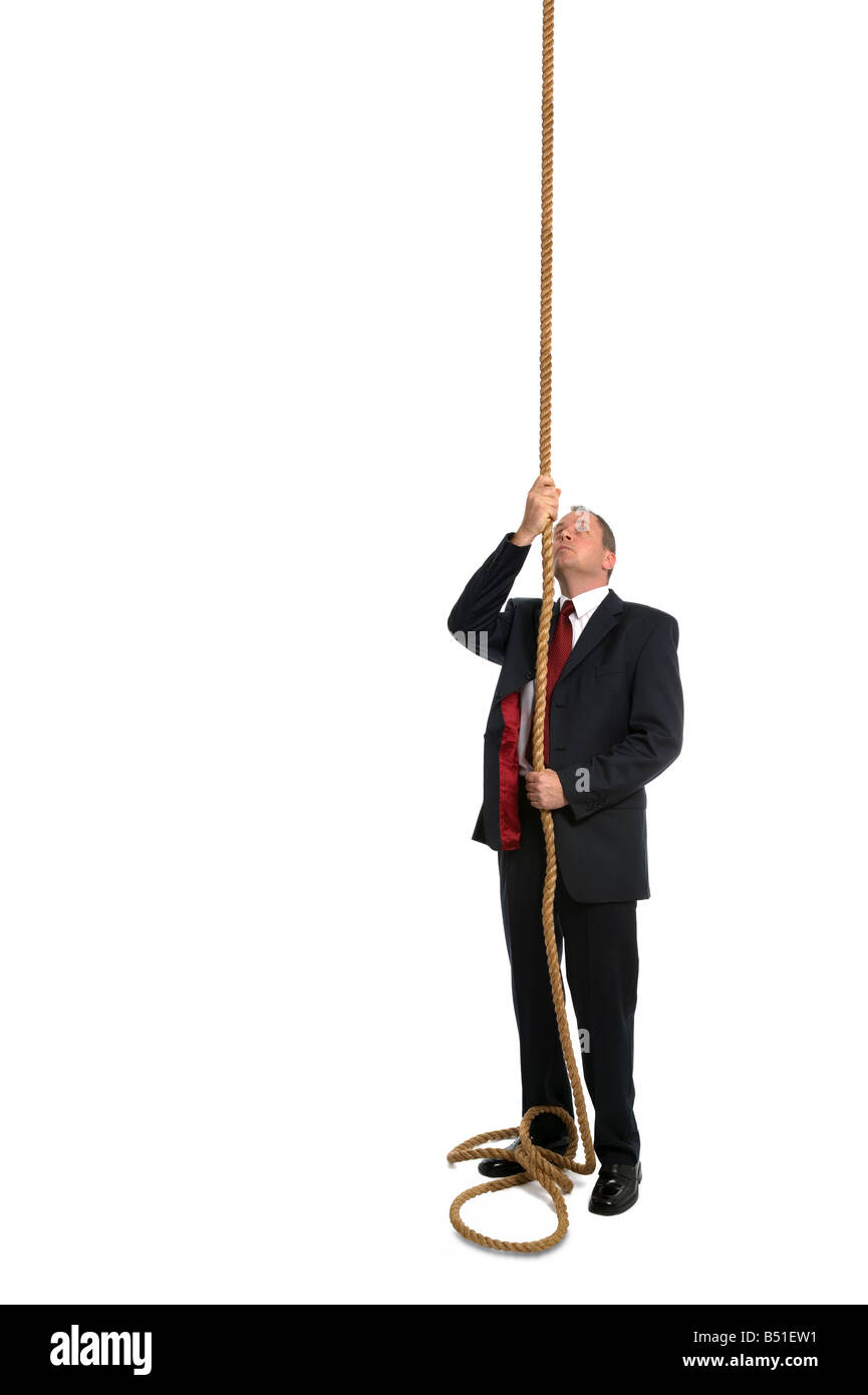 Businessman holding onto the end of a rope thats going up in the air concept shot add something to the end of the rope Stock Photo