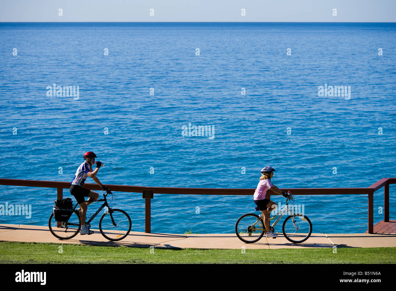 Senior couple on mountain, tracking bikes cycling along the ocean in Australia at Point Danger, Coolangatta. Stock Photo