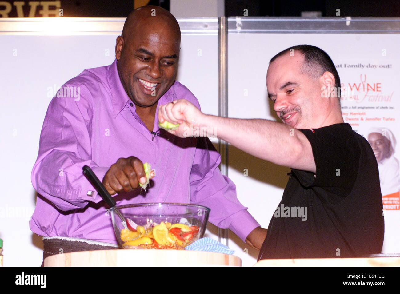 Belfast Food And Wine Festival At The King s Hall June 2002 Ainsley Harriott cooks up a special dish with the help of Belfast man Peter Kennedy at the opening of the Belfast Food and Wine Festival in the King s Hall Stock Photo