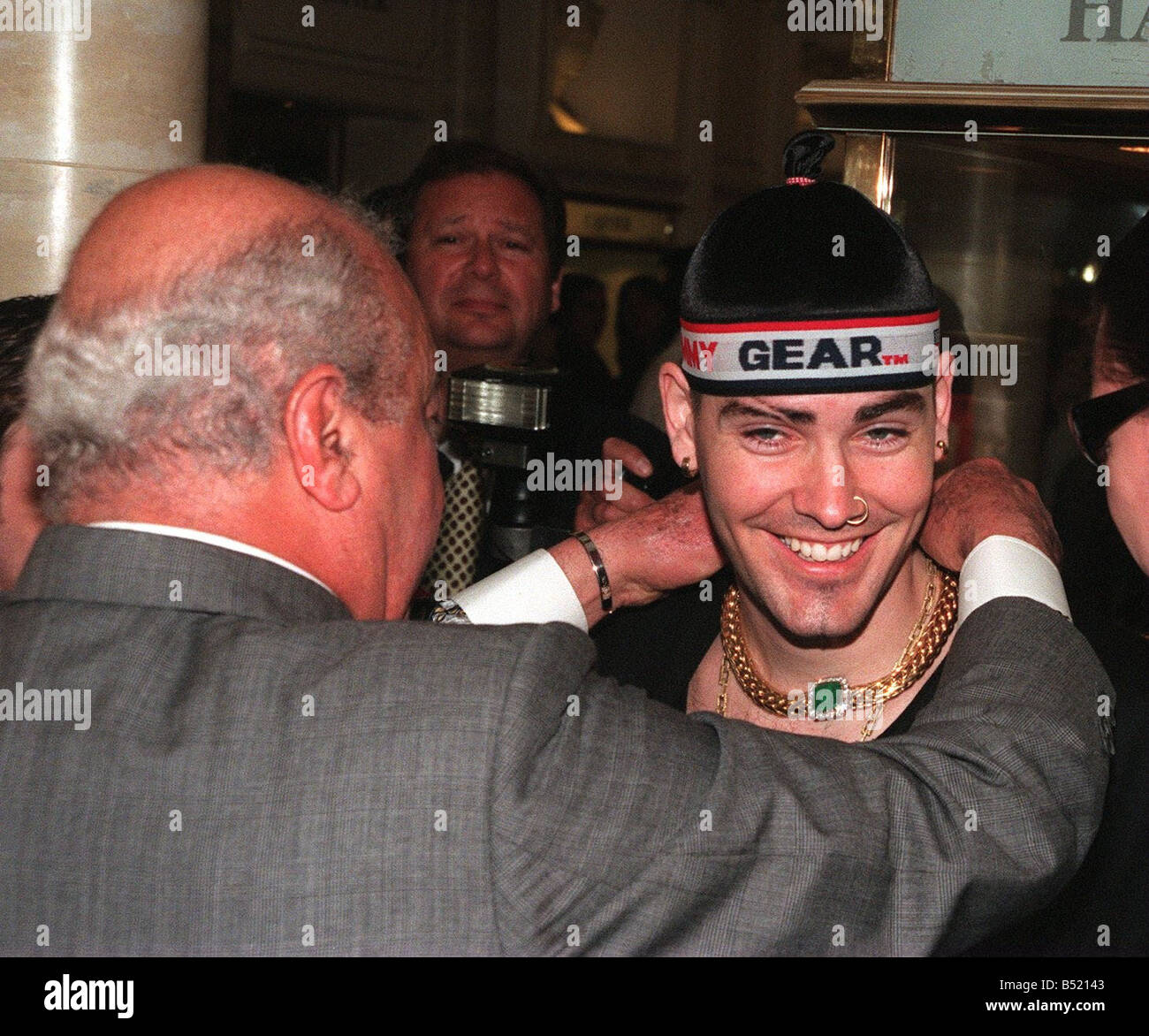 Mohamed Al Fayed and Boyzone opening Harrods sale 1998 Al Fayed puts The Kojis necklace on Shane Lynch Stock Photo