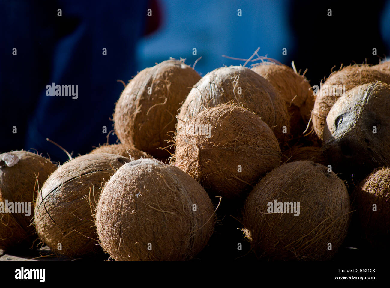 Husked coconuts sit in a stack Stock Photo