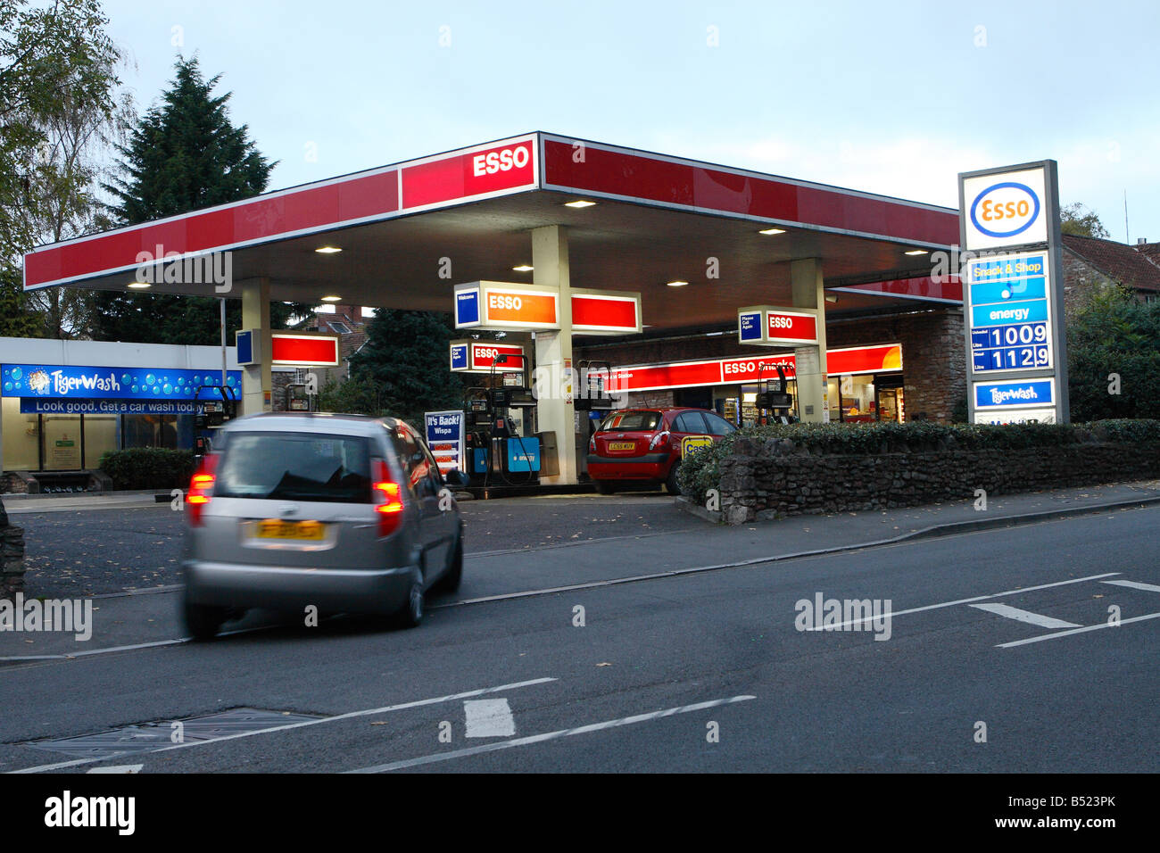 Esso petrol fuel station garage forecourt at dusk with car entering to buy petrol Stock Photo