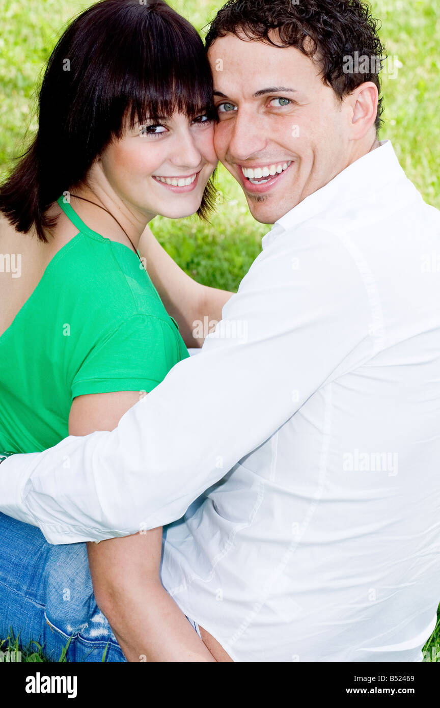 Young happy and smiling couple in a park Stock Photo - Alamy