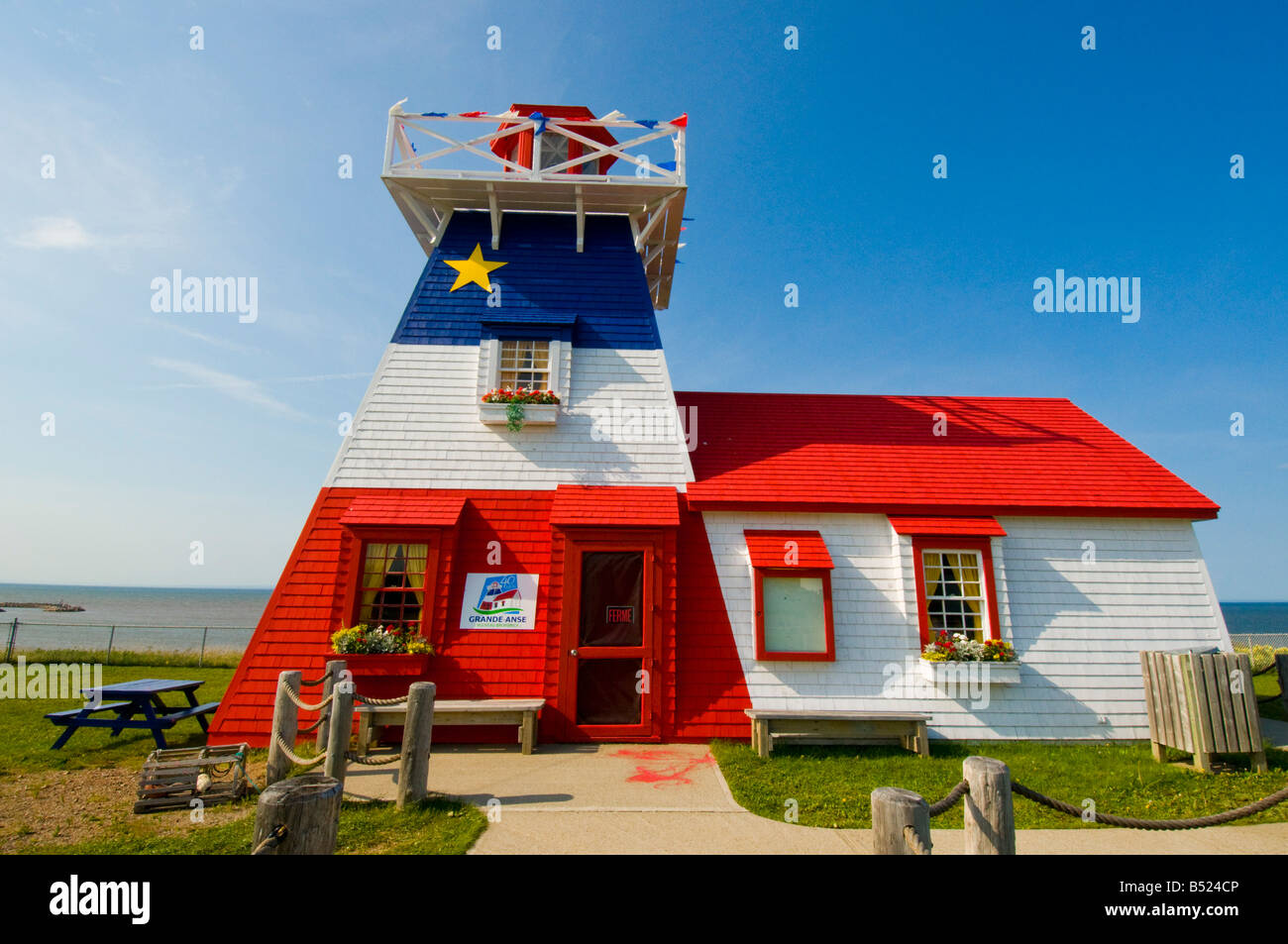 Lighthouse with Acadian flag in Grande Anse Acadian Peninsula New Brunswick Stock Photo
